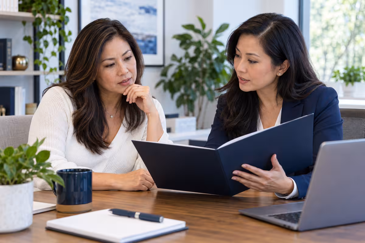 A homeowner and advisor review insurance terms in a loan offer.