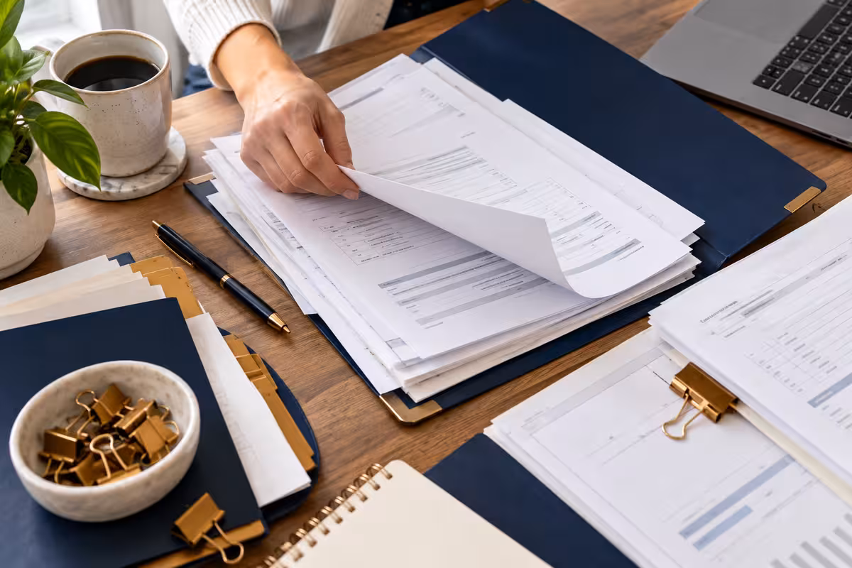 A person sorting printed financial statements at a desk
